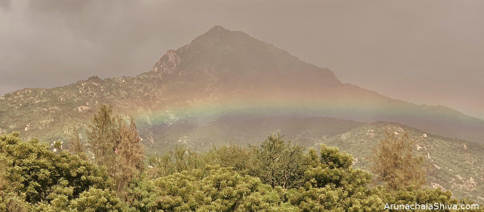 Arunachala hill after rain, a rainbow arching over the sacred mountain at Tiruvannamalai